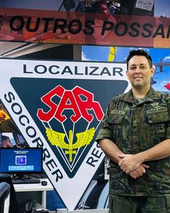 Walter Robôs de farda ao lado do emblema de busca e salvamento